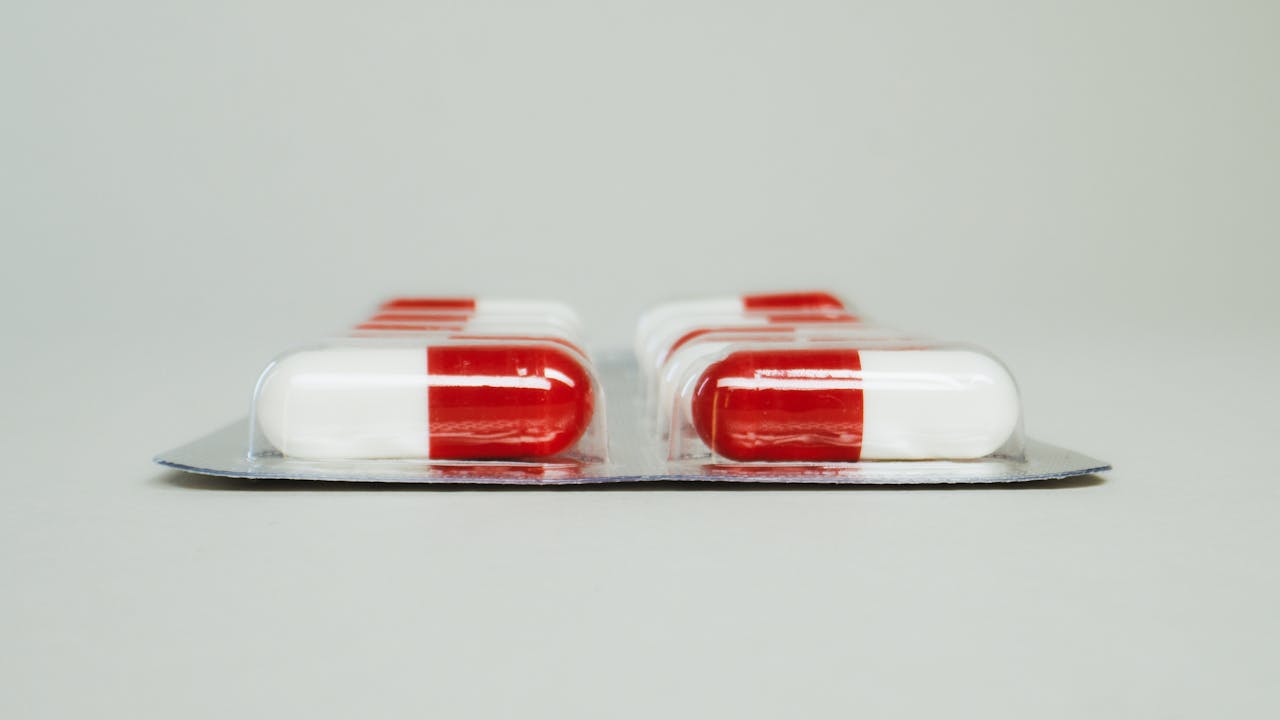Blister pack of red and white capsules isolated against a simple background.